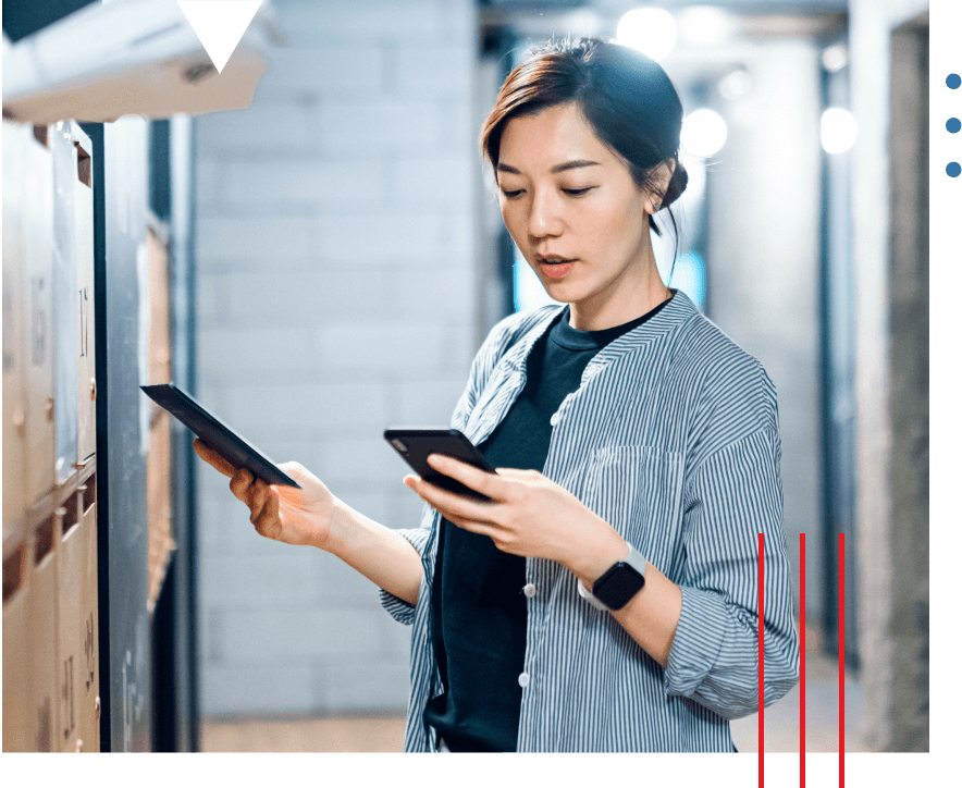 A woman looks at her phone in one hand, holding a mailpiece in the other