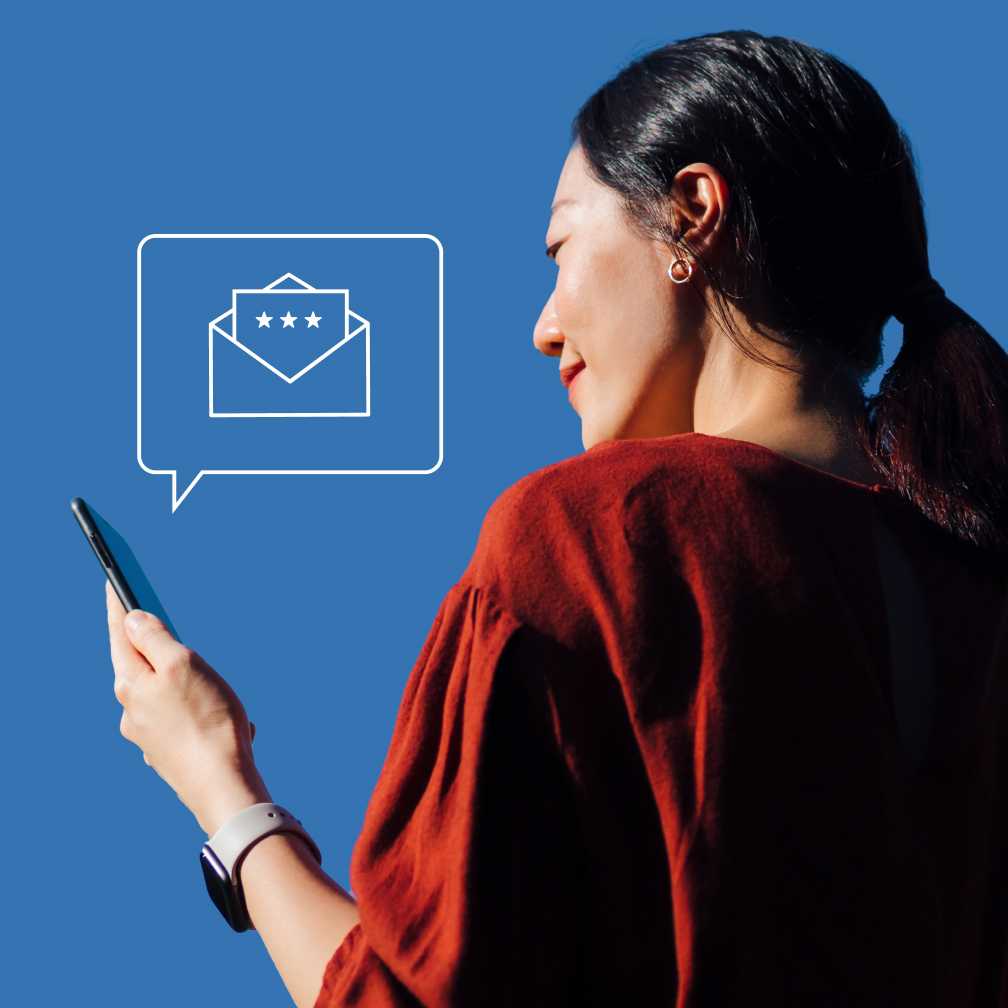 A woman looks at her phone, which shows an Informed Delivery notification.