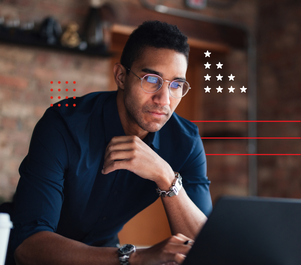 A man thoughtfully looks at his laptop screen.